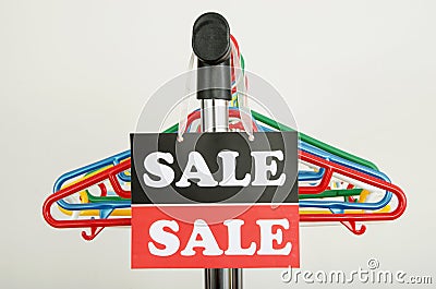 Close up on empty hangers and a big sale sign.