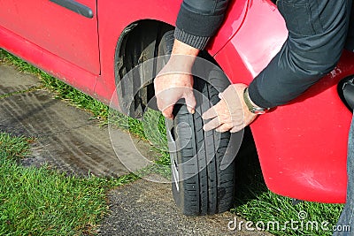 Close up of a man inspecting car tires or tyres.