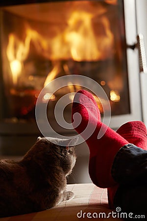 Close Up Of Mans Feet Relaxing by Fire With Cat