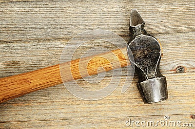 Close-up of an old hammer on wooden background