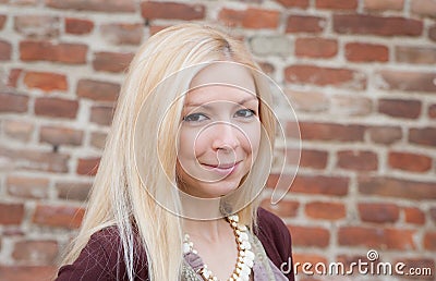 Close up portrait of a beautiful blonde girl over red wall