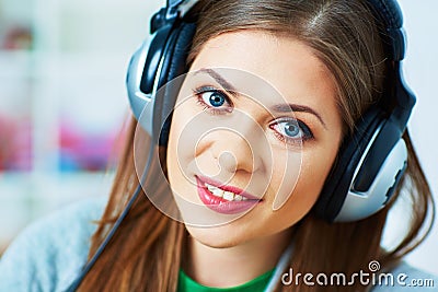 Close up portrait of young woman listening music with headphone