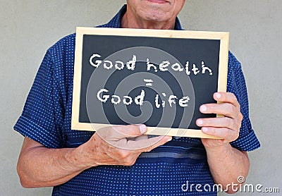 Close up of senior man holding a blackboard with the phrase good health equals good life