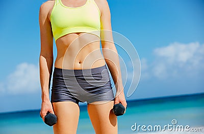 Close-up of torso of fitness woman barbells