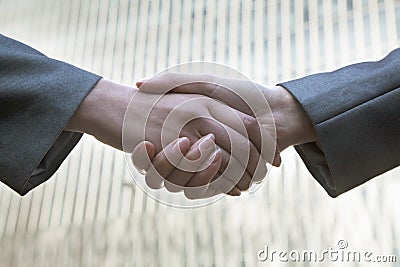 Close up of two business people shaking hands by Chinas world trade center in Beijing