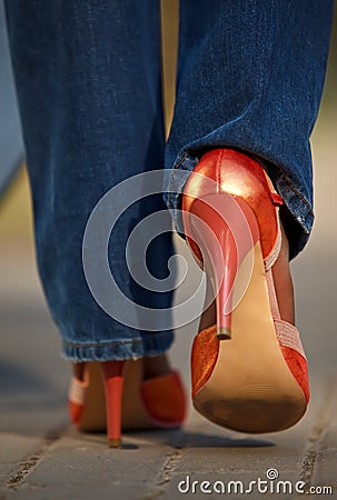 Close-up view of female in red shoes walking