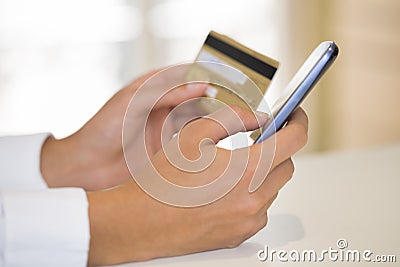 Close-up woman s hands holding a credit card and using cell phon