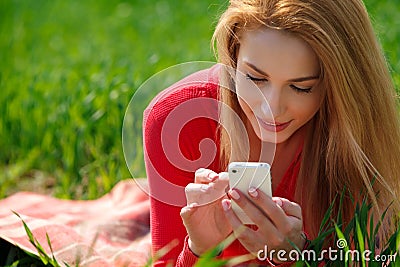 Close up of woman using mobile smart phone in the Park.