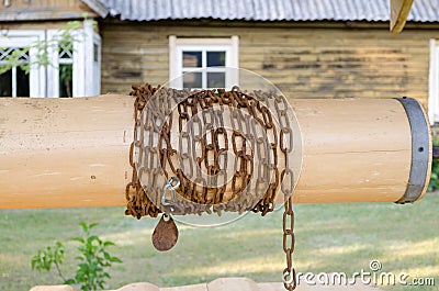 Close up wooden well roller with chain in country