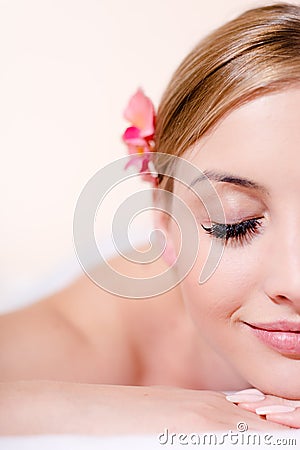 Closeup on beautiful young blond woman in spa treatments happy smiling eyes closed on white background