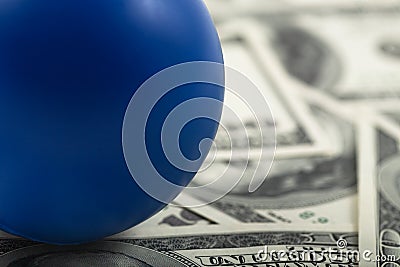 Closeup of blue ball on stack of cash