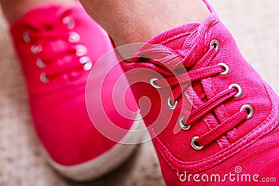 Closeup of casual vibrant pink sneakers shoes boots on female feet