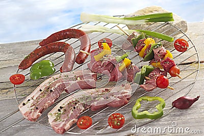 Closeup of fresh meat and sausages on barbecue grid