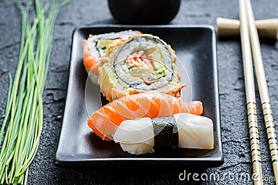 Closeup of fresh sushi, dark ceramic and chopstick