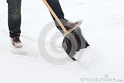 Closeup of man shoveling snow from driveway