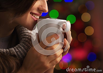 Closeup on smiling young woman with cup of hot chocolate