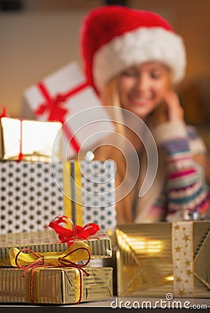 Closeup on stack of christmas present boxes and teenage girl in background