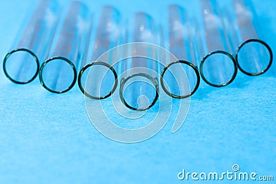 Closeup of test tube openings on blue background