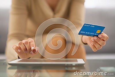 Closeup on woman with credit card using tablet pc
