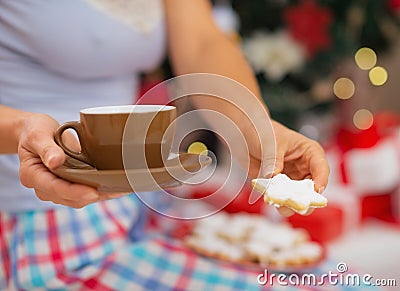 Closeup on woman in pajamas holding hot beverage