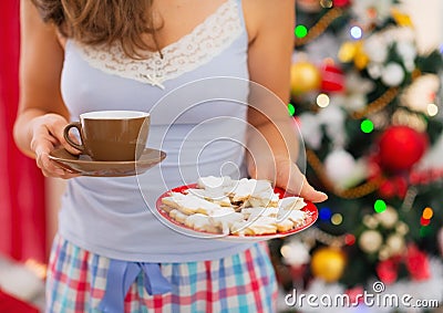 Closeup on woman in pajamas holding hot tea