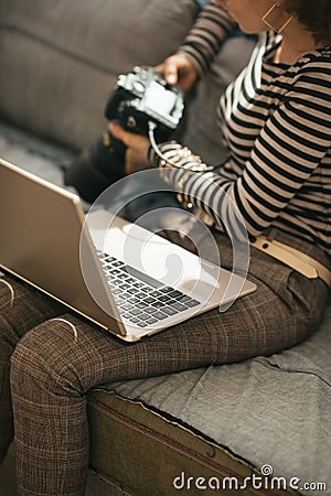 Closeup on young woman with laptop using dslr