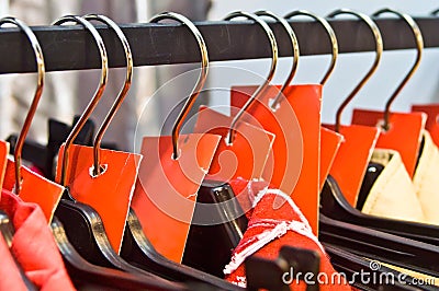 Clothes hangers with sale red labels in a shop