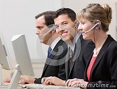 Co-workers working at computers in call center