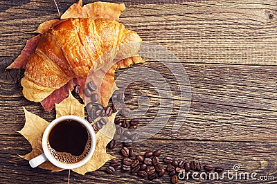 Coffee, croissant and autumn leaves