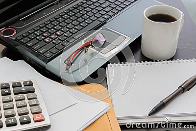 Coffee cup, laptop, Document file , pen , Calculator , notepad a