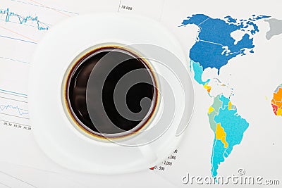 Coffee cup over world map and financial documents - view from top