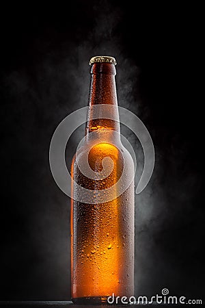 Cold beer bottle with drops on black