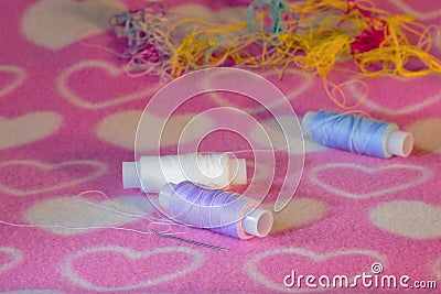 Colored thread and needle on fabric