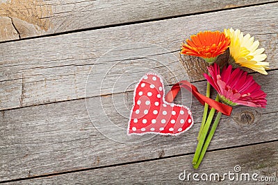Colorful gerbera flowers and Valentine s day heart toy