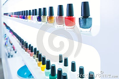 Colorful nail polish colors in a row at nails saloon on white