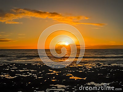 Colorful sunset with clouds by the ocean