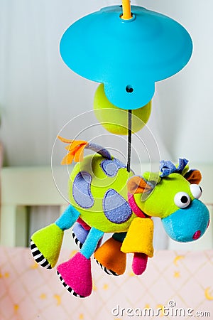 Colorful turning cow baby toy over the bed