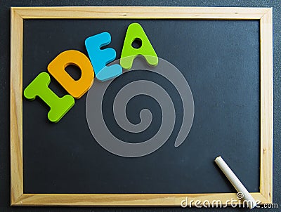 Colorful wooden word Idea on black board with white chalk
