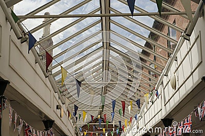 Colourful bunting flags in a glass rooved walkway