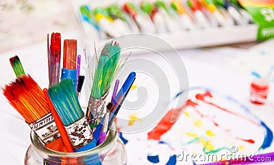 Colourful Paint Brushes with Paints in Background