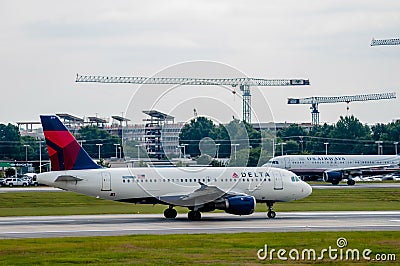 Commercial jet on an airport runway with city skyline in the bac