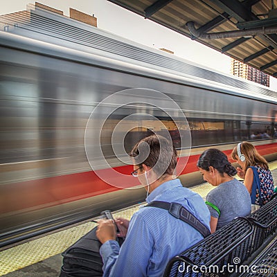 Commuters wait for a train