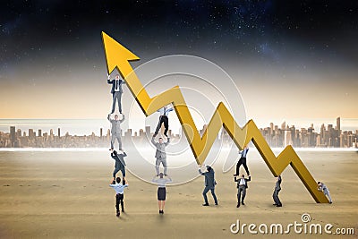 Composite image of business team holding up arrow