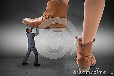 Composite image of cowboy boots stepping on businessman