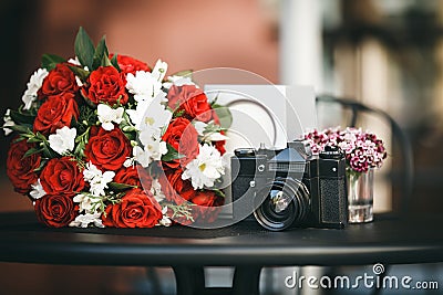 Composition of bouquet with red roses and chamomile and film cam