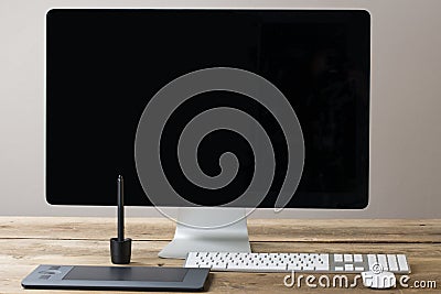 Computer screen and keyboard and mouse on a wood table with whit