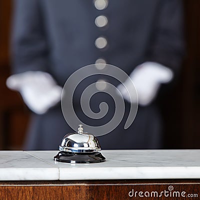 Concierge pointing to hotel bell