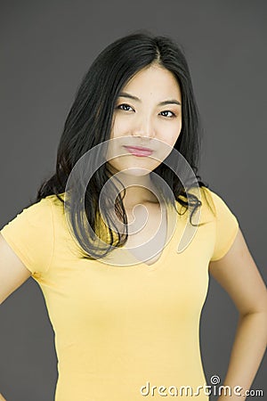 Confident Asian young woman with arms akimbo