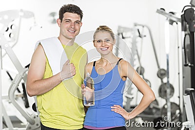 Confident Couple With Towel And Water Bottle In Gym