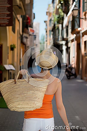 Confident woman carrying a straw shopping bag
